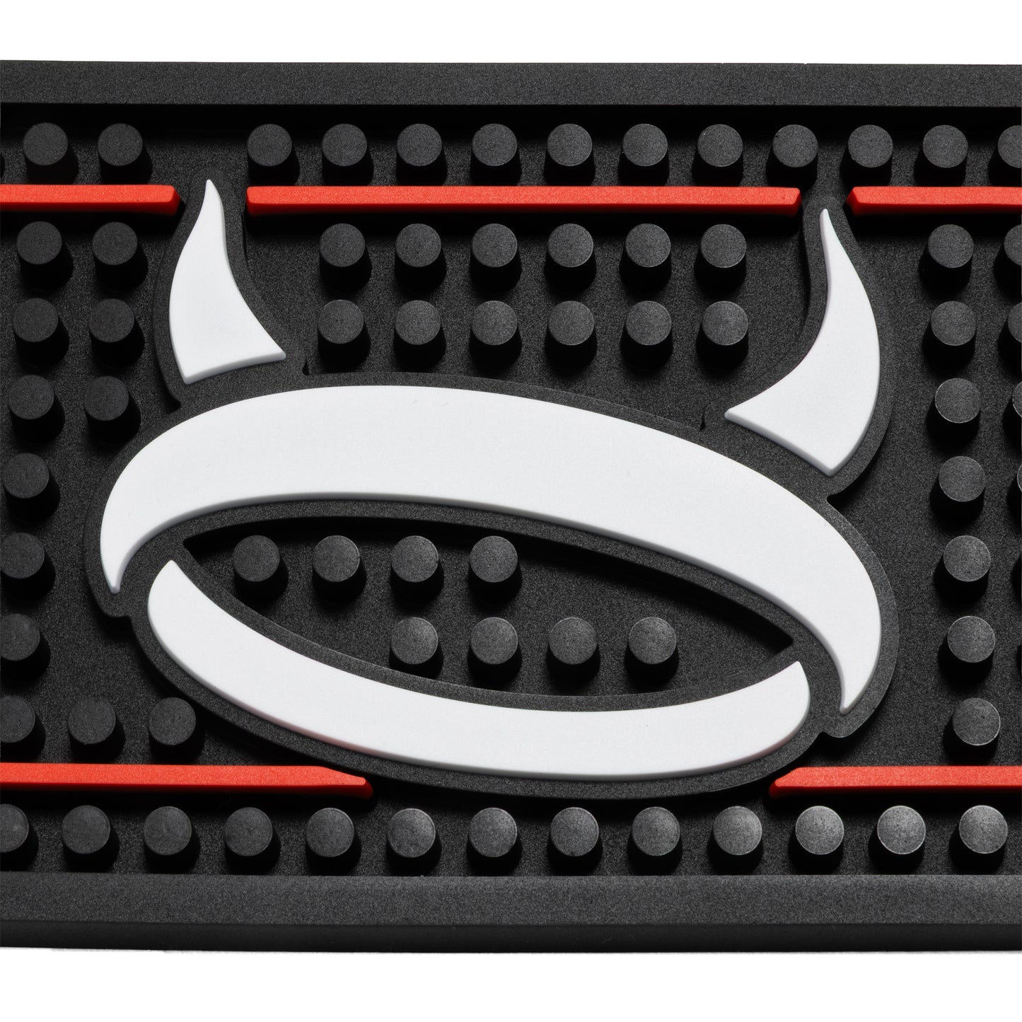 A close-up of a black textured rubber mat featuring a large white devil horn logo in the center, bordered by red lines.